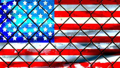 Image of US flag behind chain link fence