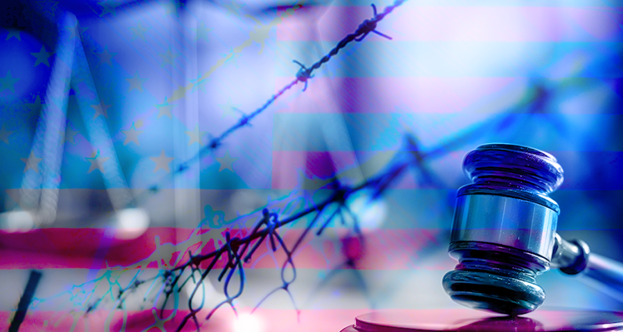 A gavel and barbed wire fence in front of an American flag